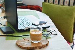 photo of a coffee cup on a desk near a computer