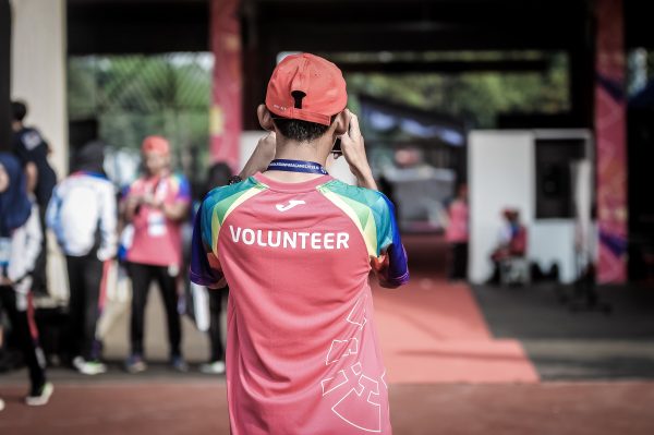 Many wearing a volunteer tee shirt taking a photo