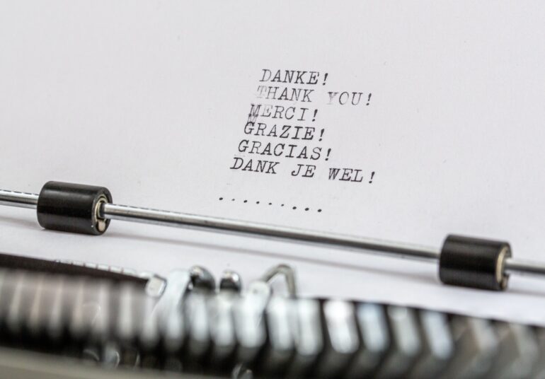 a paper in a typewriter with thank you written in different languages