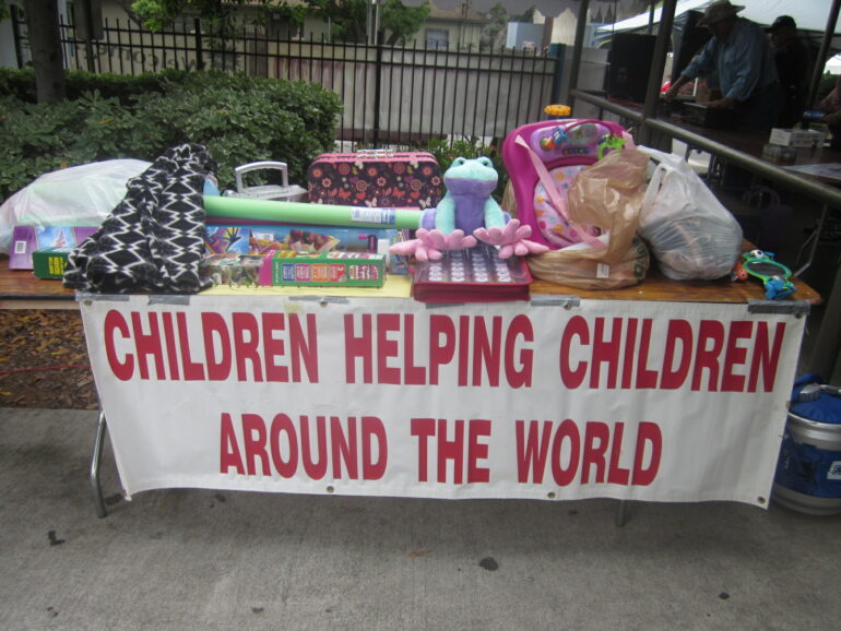 A kids auction, with a banner saying: "Children helping children around the world"