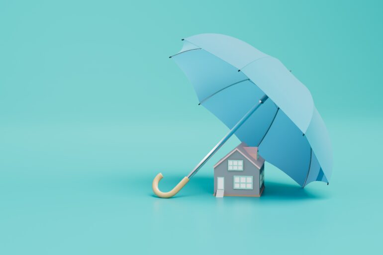 A small handmade house that is under a big blue umbrella, covering the house entirely